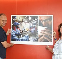 Jutta Ulmer und Michael Wolfsteiner hängen ein Bild auf